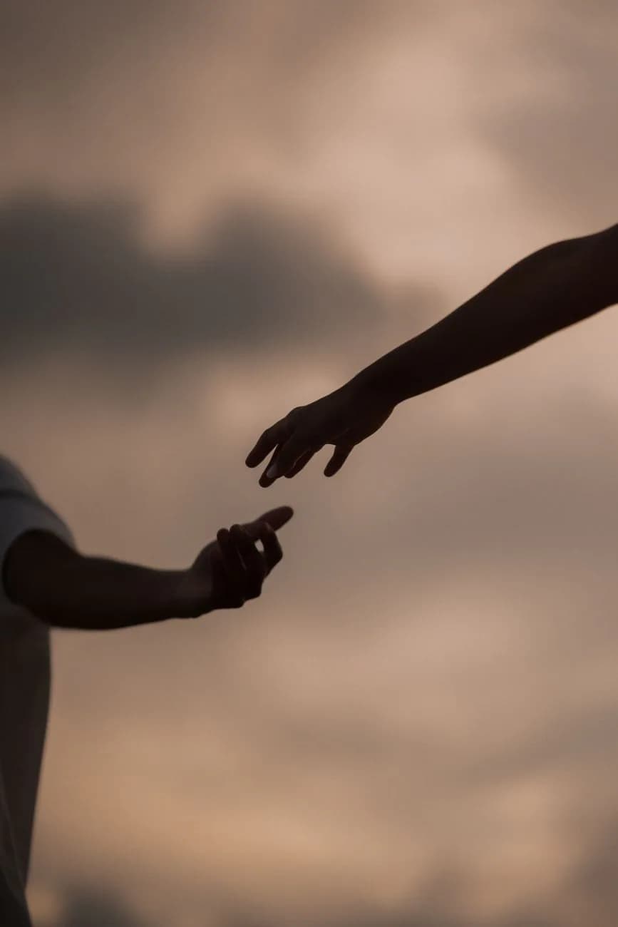 Two people reaching toward one another